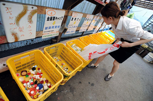 A resident divides up her bottles into clear, brown and other coloured bottles at the waste disposal site in central Kamikatsu Town in Shikoku, Japan on July 22, 2008. There are no rubbish collection services to the 800 households in the town and residents are required to carry all their non-compostible rubbish to one waste disposal site and divide it up into 34 different types for recycling. Commissioned: recycling, zero waste story Photographer: Robert Gilhooly